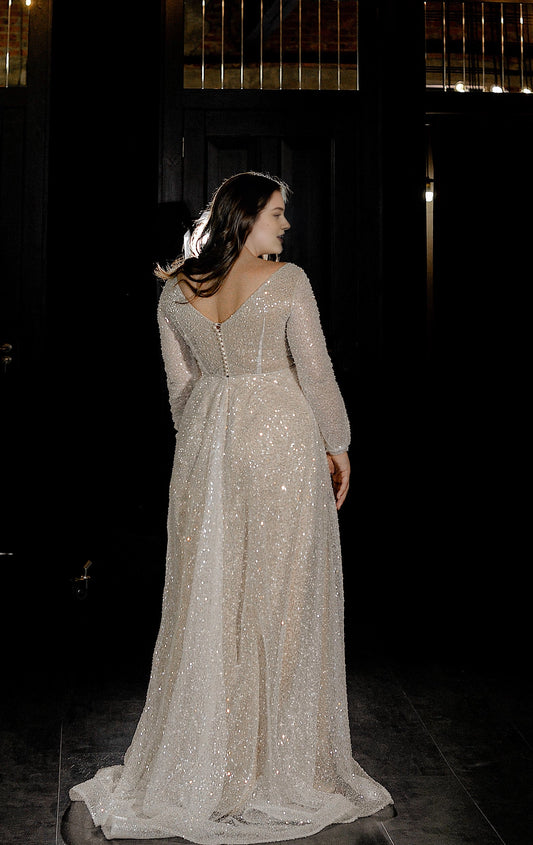 Ivory plus size wedding dress with off-shoulder sleeves, covered button back, fitted mermaid silhouette and flowing sweep train