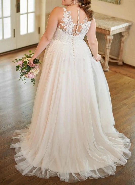 Ivory plus size wedding dress with sheer floral lace back, pearl-style buttons, fitted waist and flowing tulle train