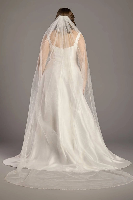 Ivory plus size wedding dress with scoop back, wide shoulder straps, fitted waist and flowing A-line skirt shown beneath a sheer bridal veil