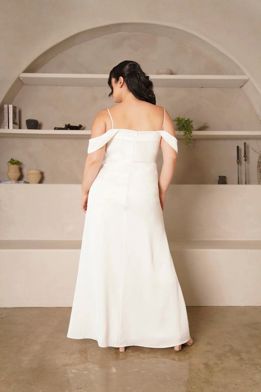 Back view of plus size ivory wedding guest dress featuring a straight back, delicate straps, draped off-shoulder sleeves, center zipper and floor-length skirt.