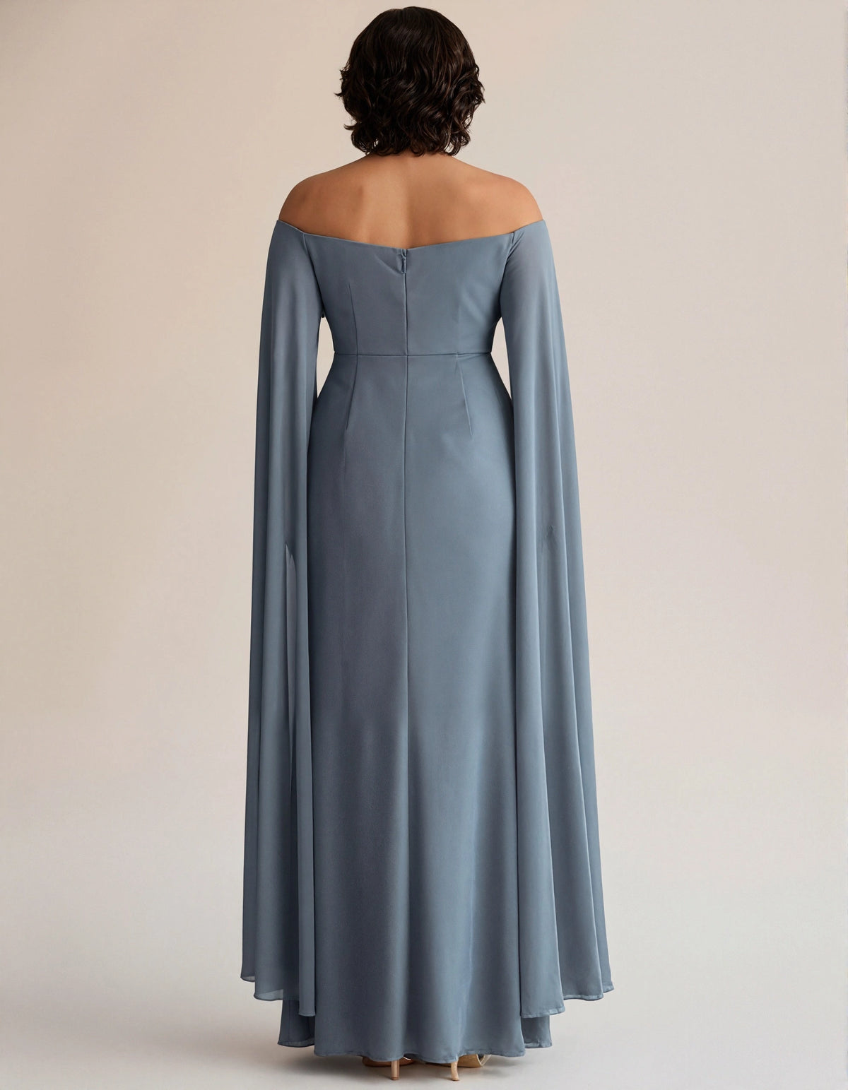 Dusty blue plus size evening gown back view, off the shoulder neckline, center back zipper, cape sleeves and long fitted skirt
