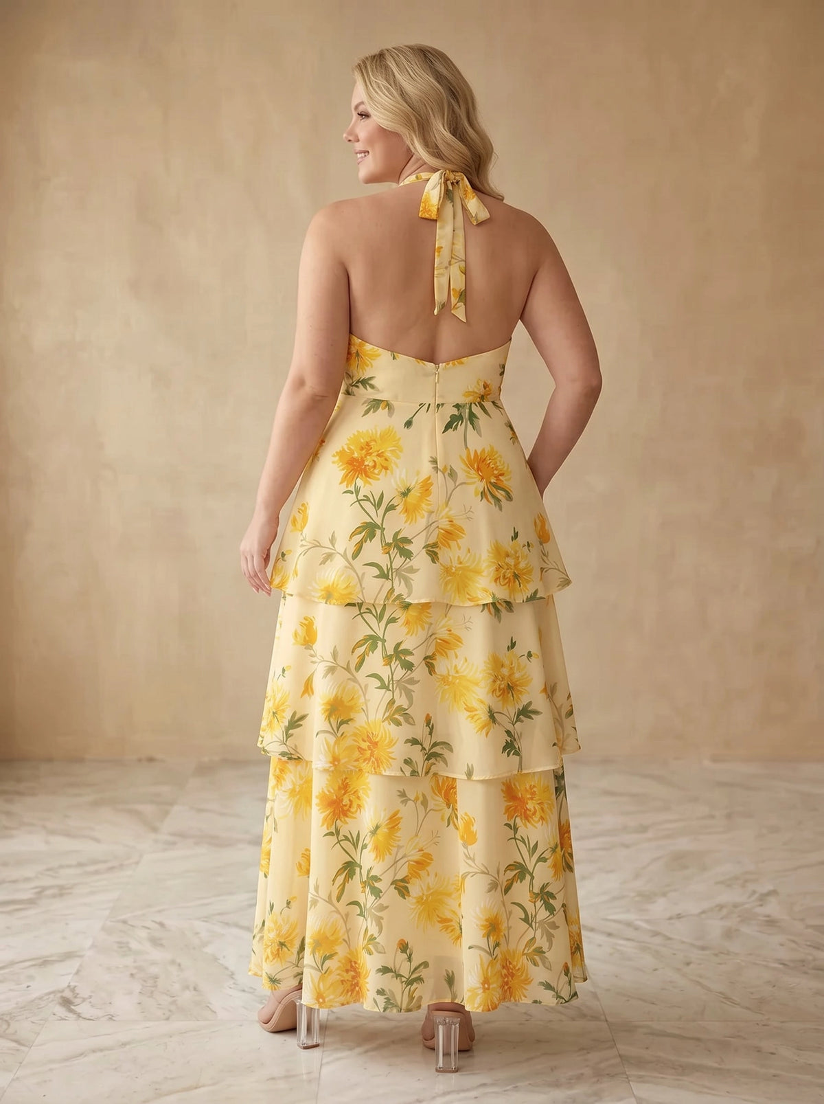 Yellow floral plus size maxi dress back view, halter tie bow at neck, open back, center back zipper and tiered ruffle skirt
