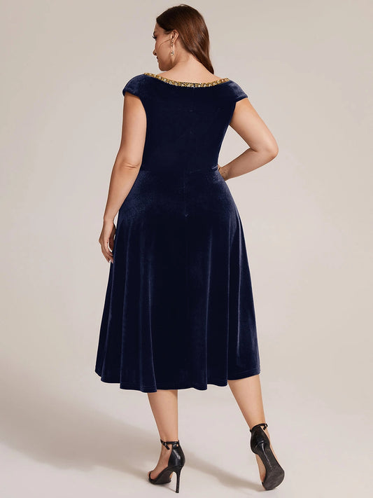Navy velvet plus size midi dress back view, bateau neck with gold trim, center back zipper, cap sleeves and A-line skirt
