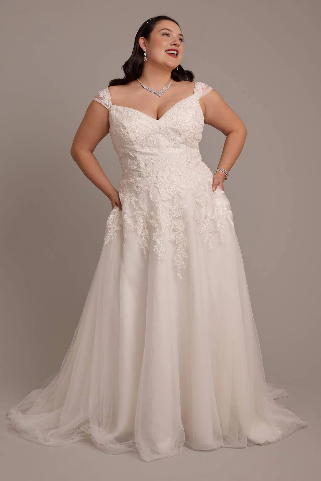 Ivory plus size A-line wedding dress with sweetheart neckline, lace cap sleeves, floral embroidery and flowing tulle skirt