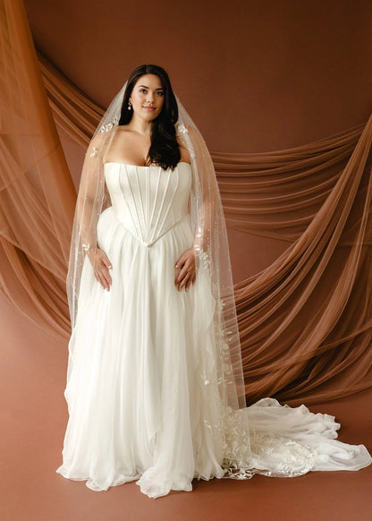 Ivory plus size A-line wedding dress with strapless corset bodice, basque waist and flowing floor-length skirt front view