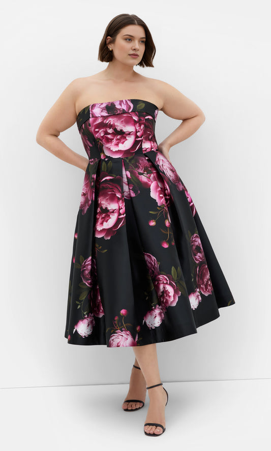 Plus size black pink peony floral satin strapless wedding guest dress with fitted bodice, pleated full tea-length skirt, front view
