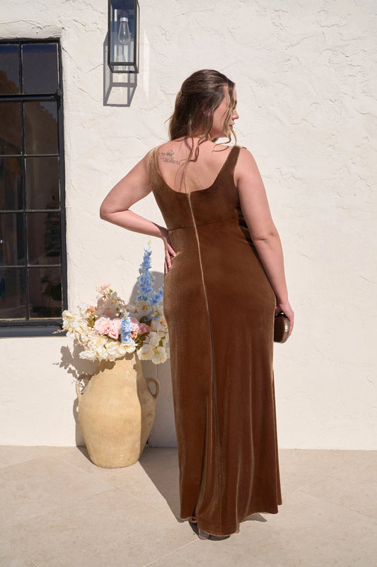 Back view of plus size chocolate brown wedding guest dress featuring a scoop neckline, wide straps, center back zipper and floor-length velvet-look skirt.