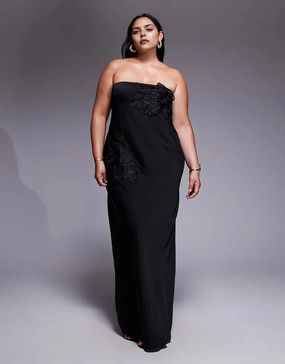 Roselledress plus size black strapless column maxi wedding guest dress with lace appliqué front view on curvy model