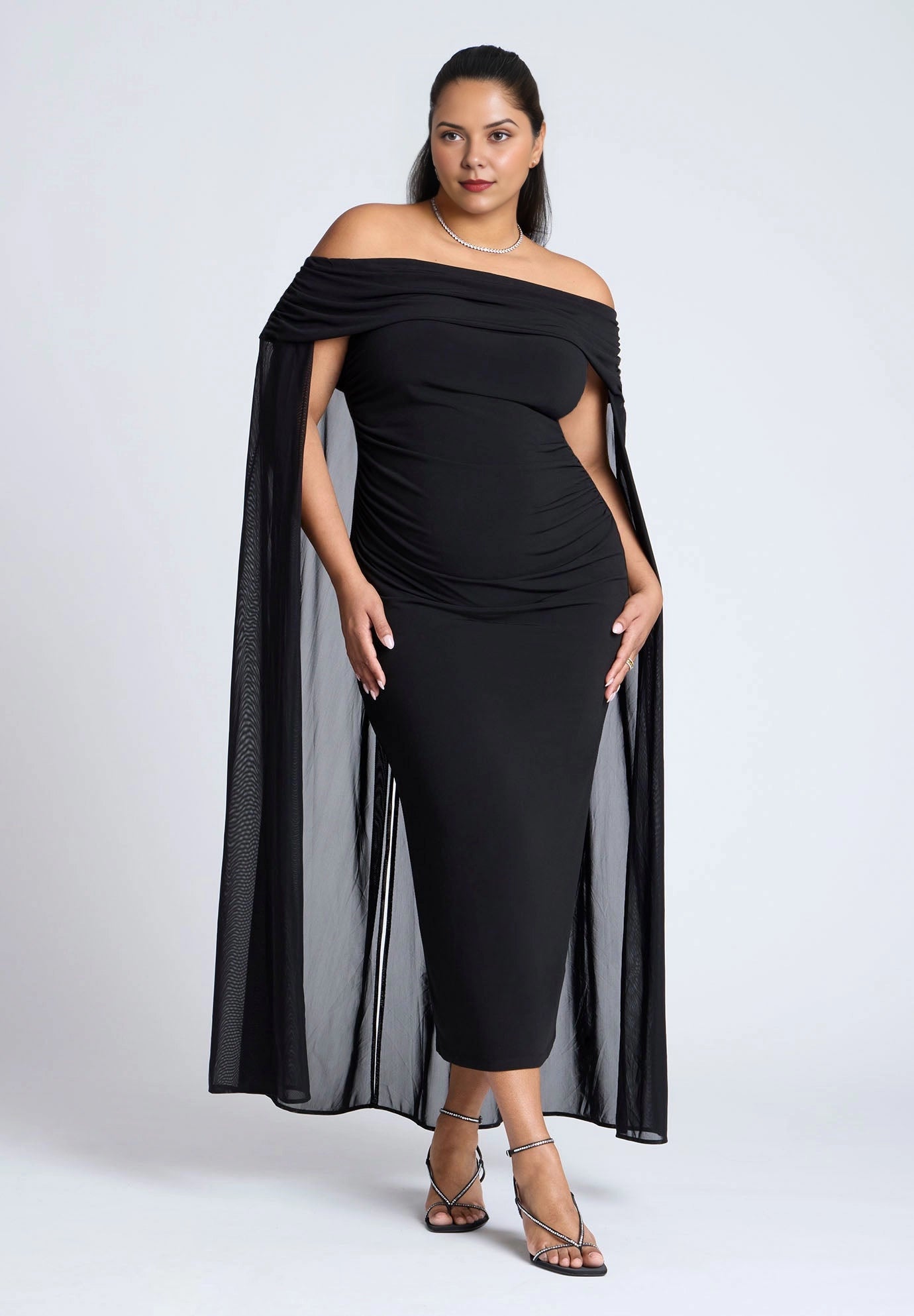 Roselle Dress plus size black off‑the‑shoulder ruched midi wedding guest dress with flowing mesh cape sleeves front view